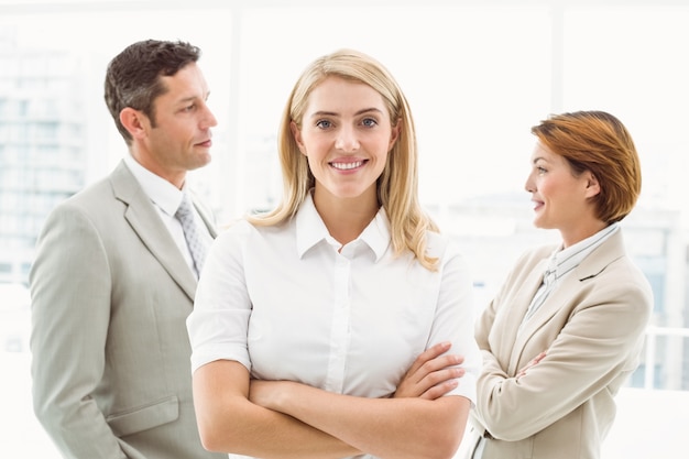 Businesswoman with colleagues behind in office