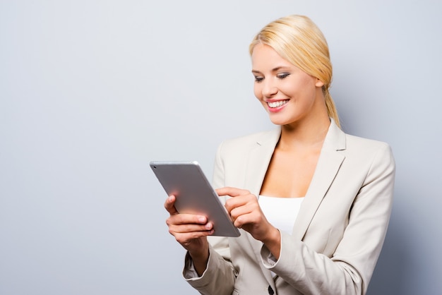 Businesswoman with digital tablet. Confident young businesswoman working on digital tablet