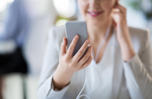 Foto donna d'affari con auricolari e smartphone