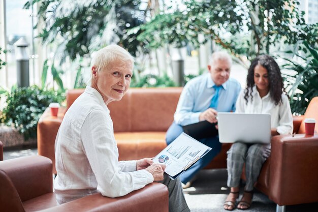 Businesswoman with a financial report sitting in the office lobby