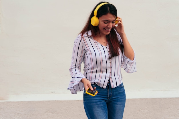 Foto imprenditrice con le cuffie tramite telefono cellulare in città