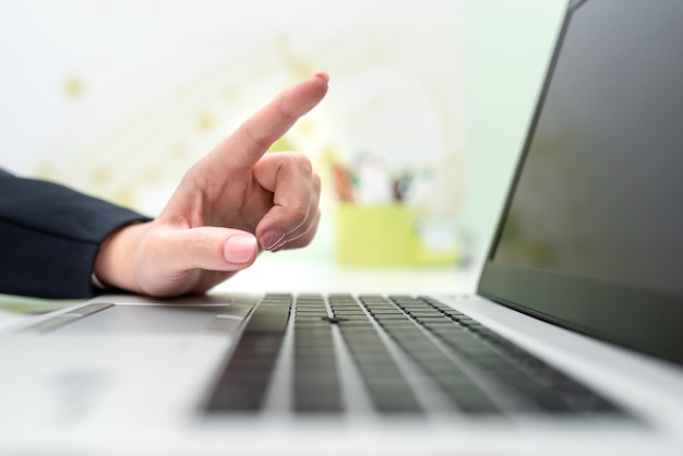 Businesswoman With Lap Top On Desk Pointing Important Messages With One Finger Executive In Office Having Computer And Presenting Crutial Informations