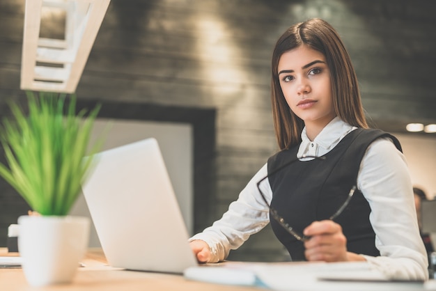 The businesswoman with a laptop sitting at the desktop