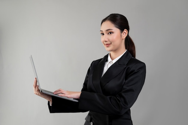 Businesswoman with laptop stands on isolated background Enthusiastic