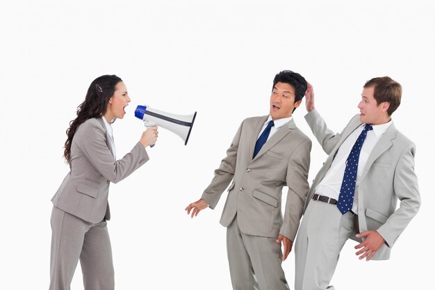 Businesswoman with megaphone yelling at colleagues