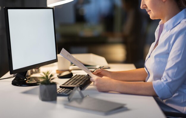 businesswoman with papers working at night office