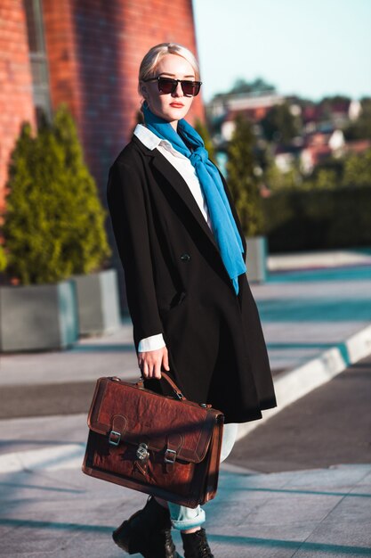 Businesswoman with suitcase outdoors