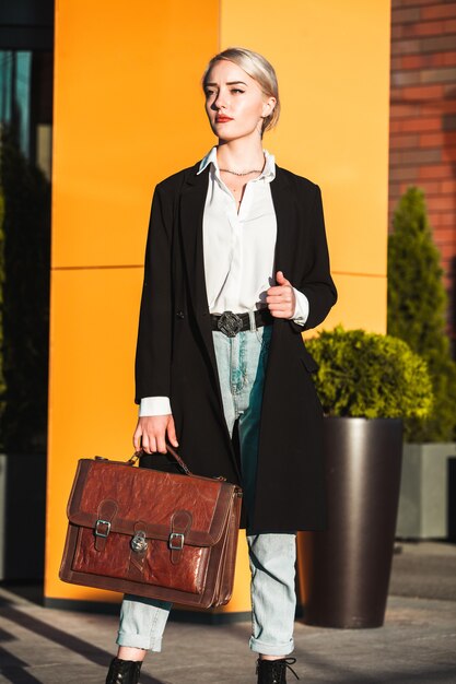 Businesswoman with suitcase outdoors