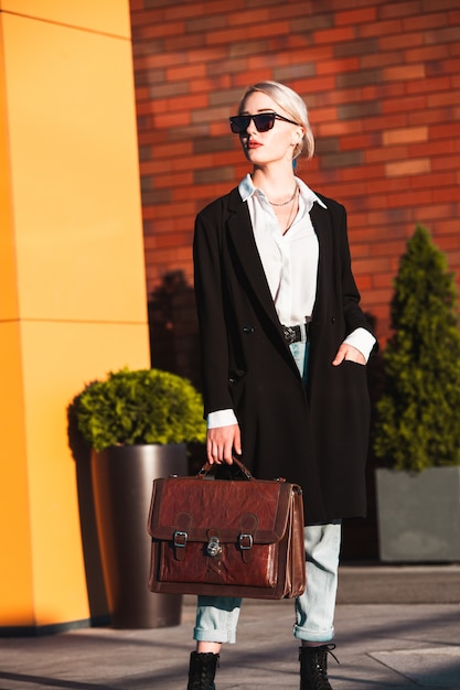 Businesswoman with suitcase outdoors