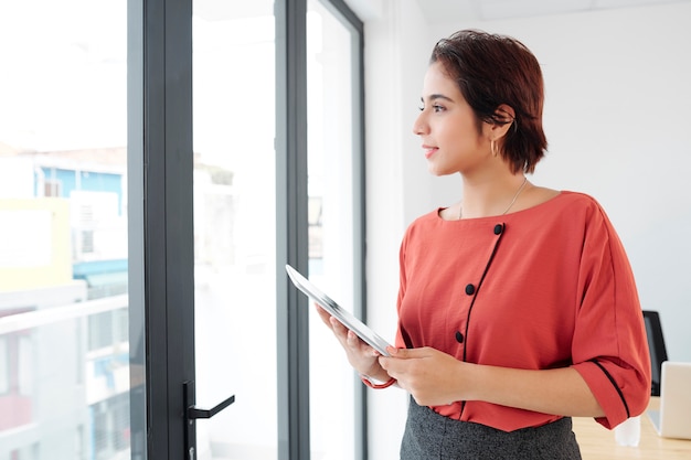 Businesswoman with tablet pc standing at office