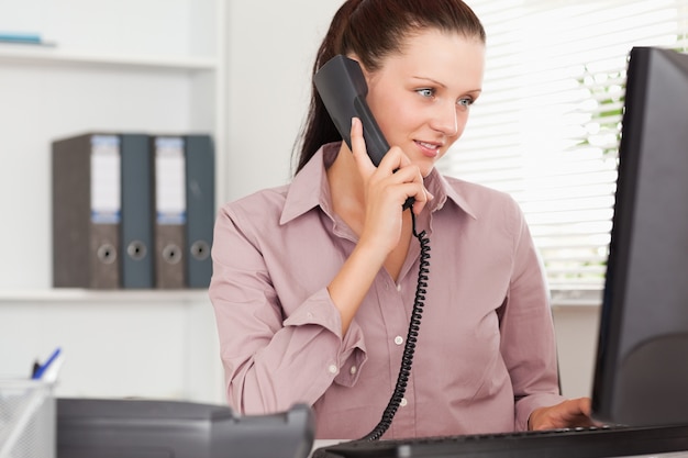 Businesswoman with telephone looking to screen