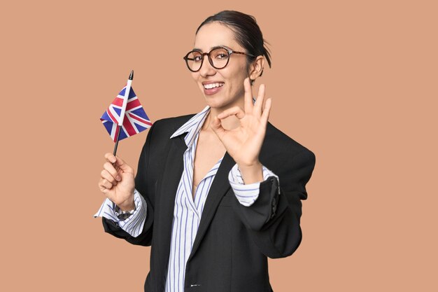 Businesswoman with UK flag symbolizing international business cheerful and confident