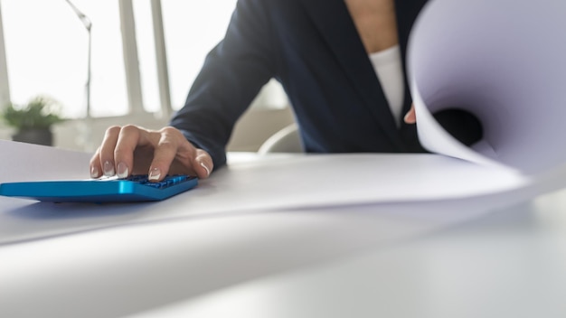 Businesswoman working on a blue manual calculator