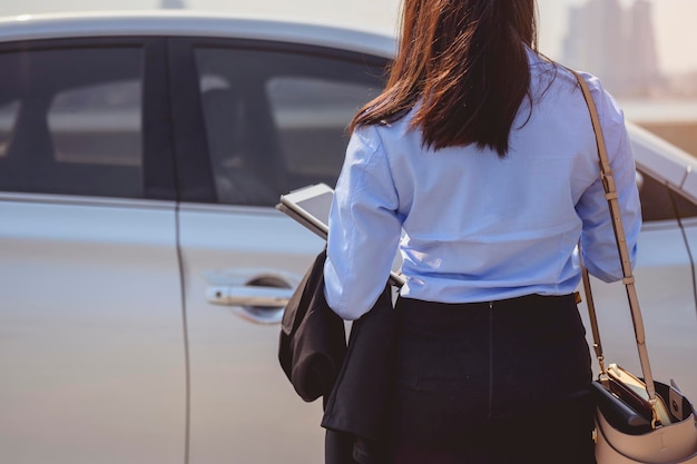 Businesswoman, working, business, car, multitasking, technology\
concept. close-up of the hand, businesswoman opening the car door\
with coffee cup and laptop.