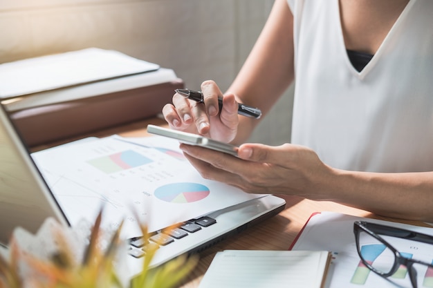 Businesswoman working on Desk office with marketing graph statistics analysis