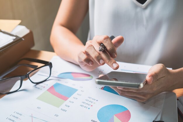 Businesswoman working on Desk office with marketing graph statistics analysis