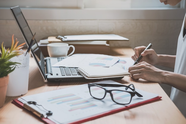 Businesswoman working on Desk office with marketing graph statistics analysis