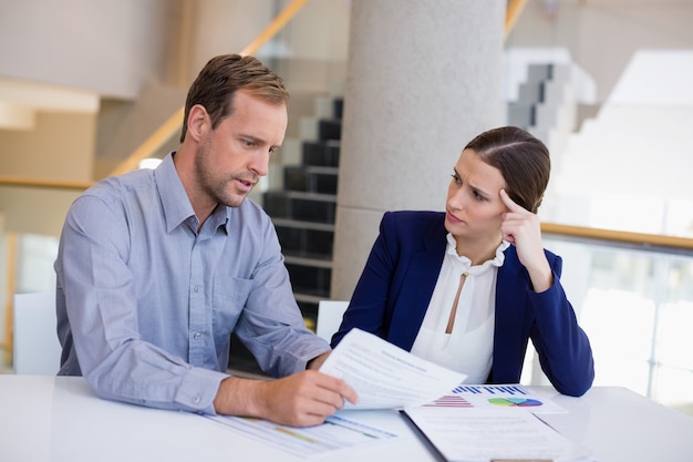 Businesswoman working at desk with colleague