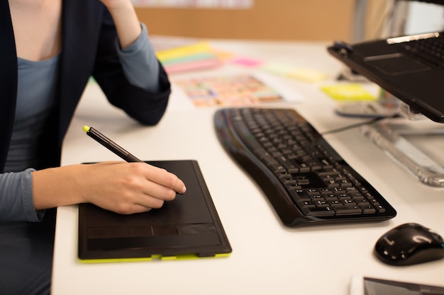 Donna di affari che lavora al digitalizzatore allo scrittorio