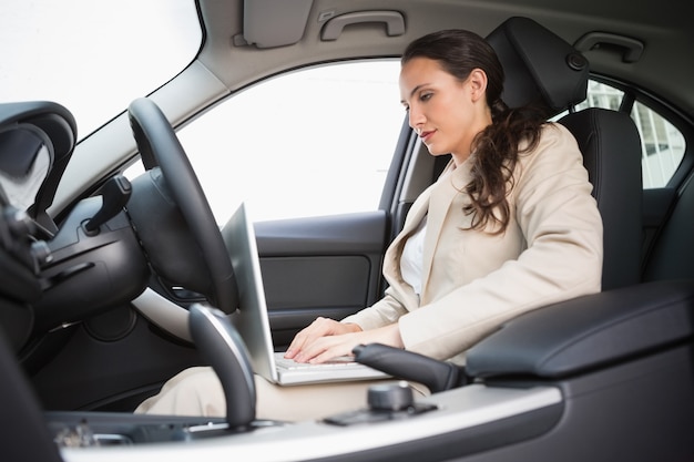 Businesswoman working in the drivers seat