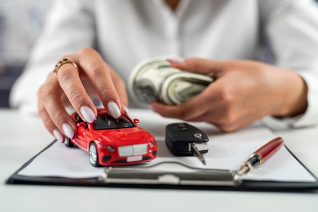 Photo businesswoman working on insurance documents with a small car on the table