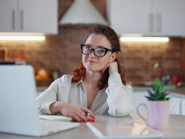 Businesswoman working on laptop computer sitting at home