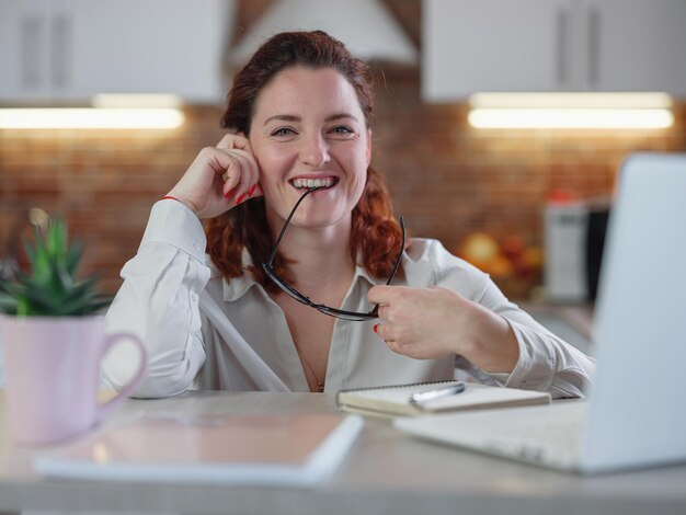 Businesswoman working on laptop computer sitting at home