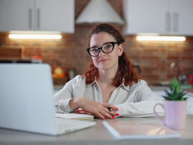 Businesswoman working on laptop computer sitting at home