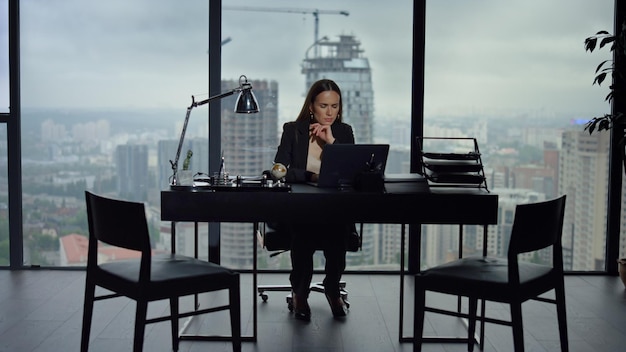 Businesswoman working on laptop in office Female employee using laptop computer