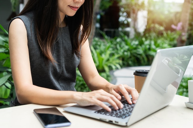 Foto imprenditrice che lavora al computer portatile mentre è seduto in giardino. concetto di business e tecnologia