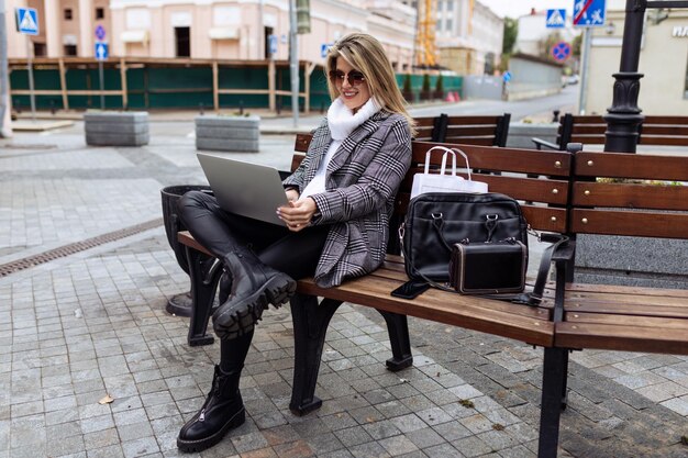 Businesswoman working remotely on a laptop in the city running a successful business concept