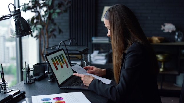 Imprenditrice che lavora sul posto di lavoro con documenti donna che pensa al progetto