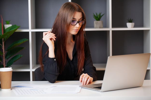 Businesswoman works in the office at a white table