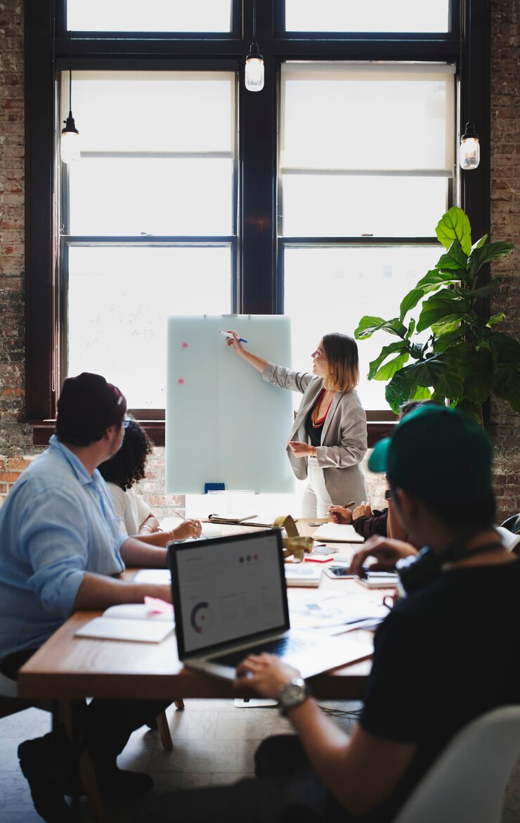 Photo businesswoman writing on a board in the meeting room