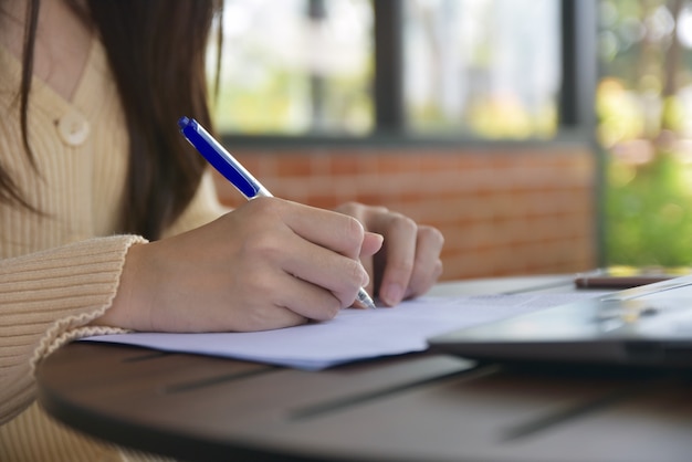 Businesswoman writing on document at the office