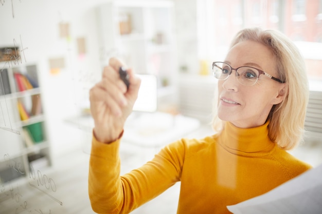 Businesswoman Writing on Glass