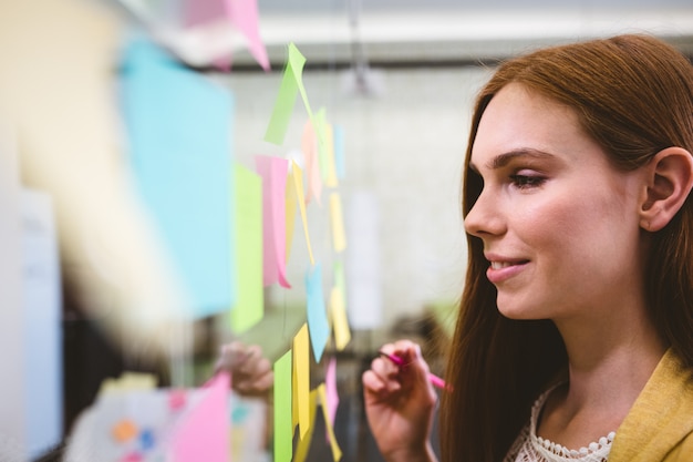 Businesswoman writing on sticky notes