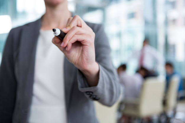 Businesswoman writing with marker on glass