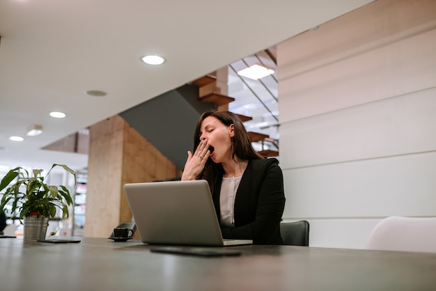 Businesswoman yawning at workplace.