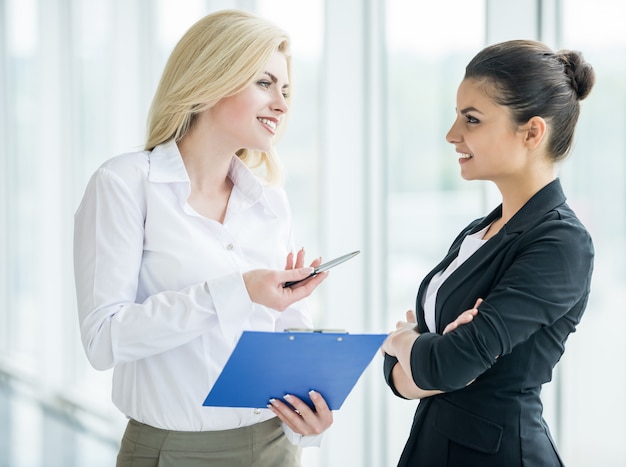 Businesswomen dressed formal discuss project at office.