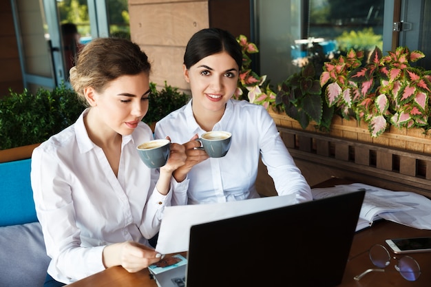 Businesswomen drink coffee in a cafe. Lunch break