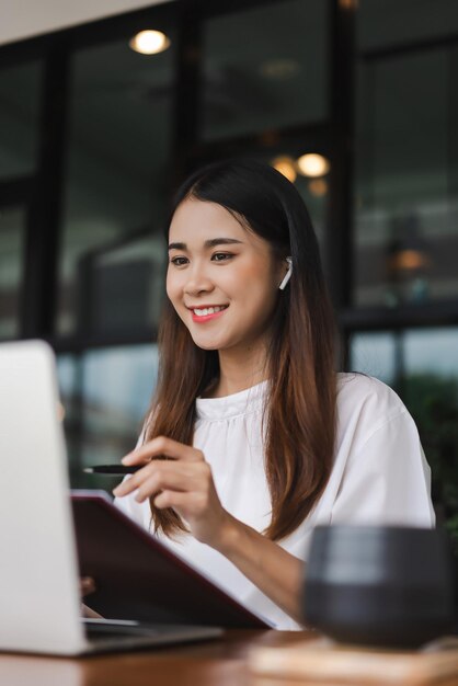 Businesswomen listening music while reading data on laptop and checking document in outside office