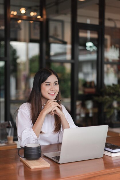 Businesswomen looking outside to thinking about new startup and working on tablet in outside office