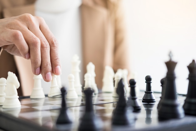 Businesswomen playing chess game makes her move