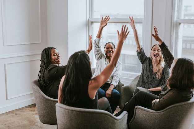 Photo businesswomen putting hands in the middle