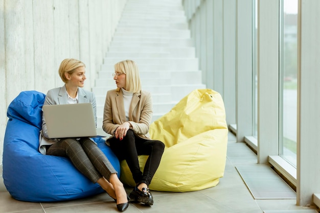 Businesswomen using laptop computer on lazy bags in the modern office