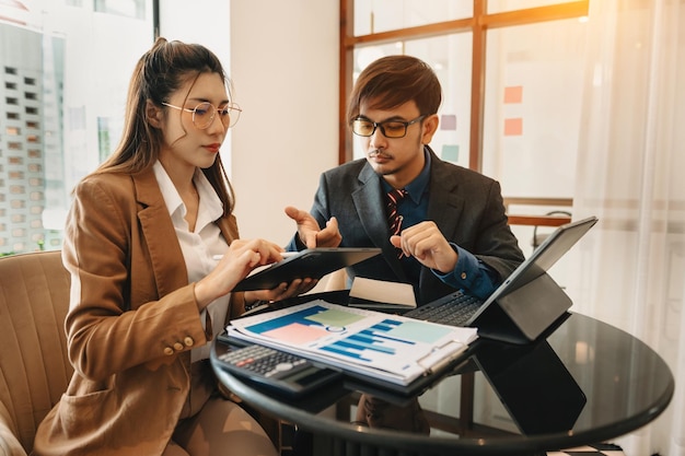 Businesswomen work and discuss their business plans A Human employee explains and shows her colleague the results paper in officexA