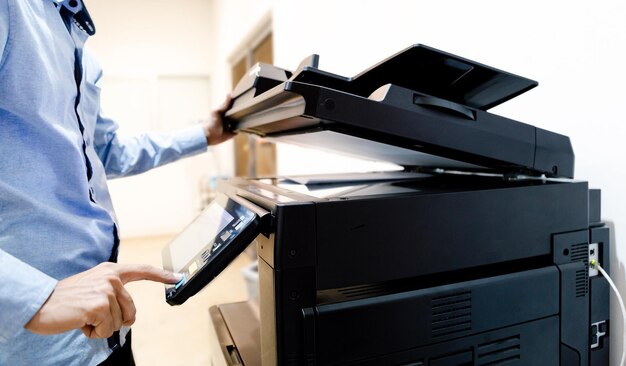 Bussiness man hand press button on panel of printer, printer\
scanner laser in office copy machine supplies start concept.