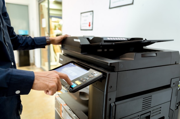 Bussiness man mano premere il pulsante sul pannello della stampante