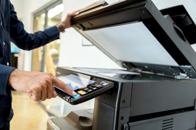 Bussiness man Hand press button on panel of printer.